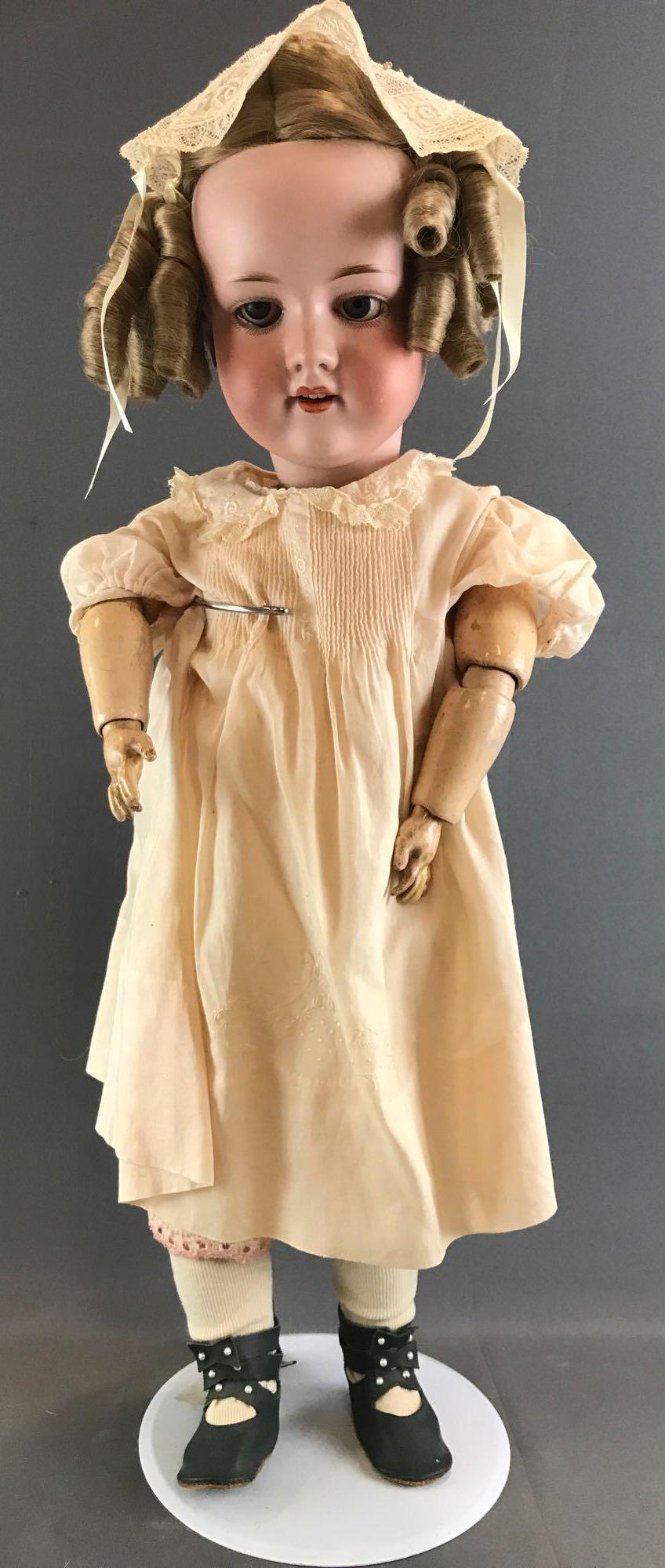 Antique 25 inch German bisque doll Marseille: Armand Marseille, 390n, DRGM 246/1 A 11 M. Socket head, blue glass sleep eyes with painted lashes, open mouth with teeth, composition and wood jointed body. Pale peach dress with under garments, stock