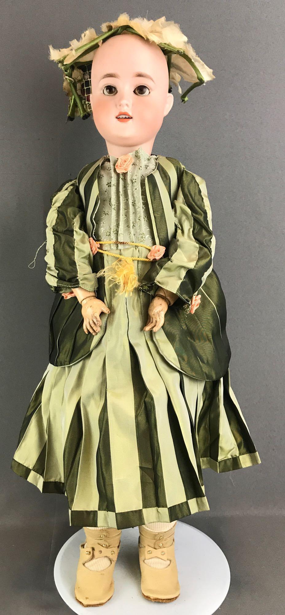 Antique 22 inch German bisque doll marked Special: Head reads Special 4 Germany. Socket head, brown sleep eyes with painted lashes, open mouth with teeth, composition and wood jointed body. Green striped dress and head piece, under garments, stockings