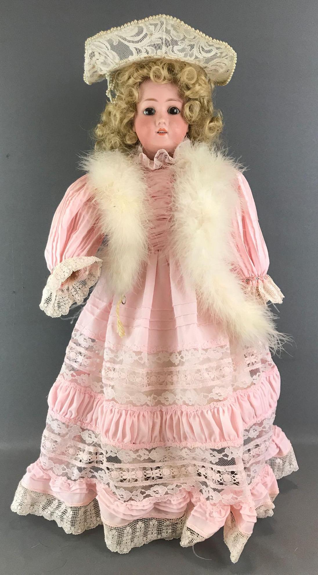 Antique 24 inch German bisque doll: Head reads Germany B3, no other markings. Socket head, brown glass sleep eyes with painted lashes, open mouth with teeth, composition and wood jointed body. Pink dress with lace, boa, under garments, 