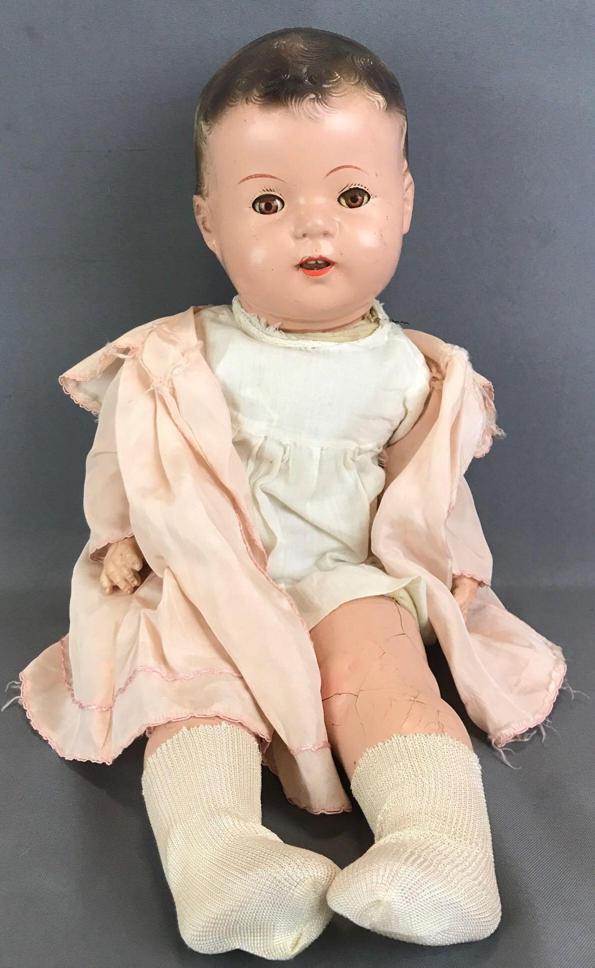 Vintage composition ba doll: No markings, open mouth with teeth, brown sleep eyes with applied lashes, fabric body, composition limbs. Ivory colored dress, pink jacket, socks. Sculpted painted hair, legs have cracking, hands and 