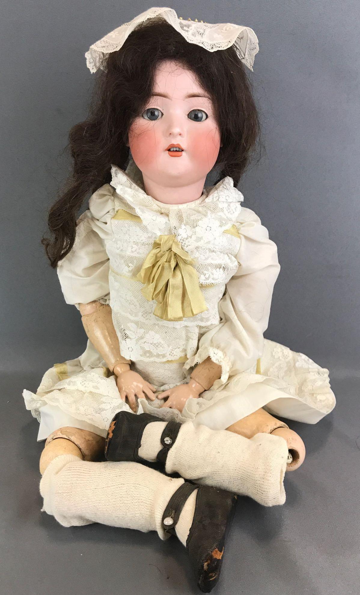 Antique 28 inch German bisque doll Bruno Schmidt: BSW in heart, Made in Germany, 14. Socket head, blue glass stationary eyes with painted bottom lashes, open mouth with teeth, composition and wood jointed body. Ivory colored dress with lace and ribbo