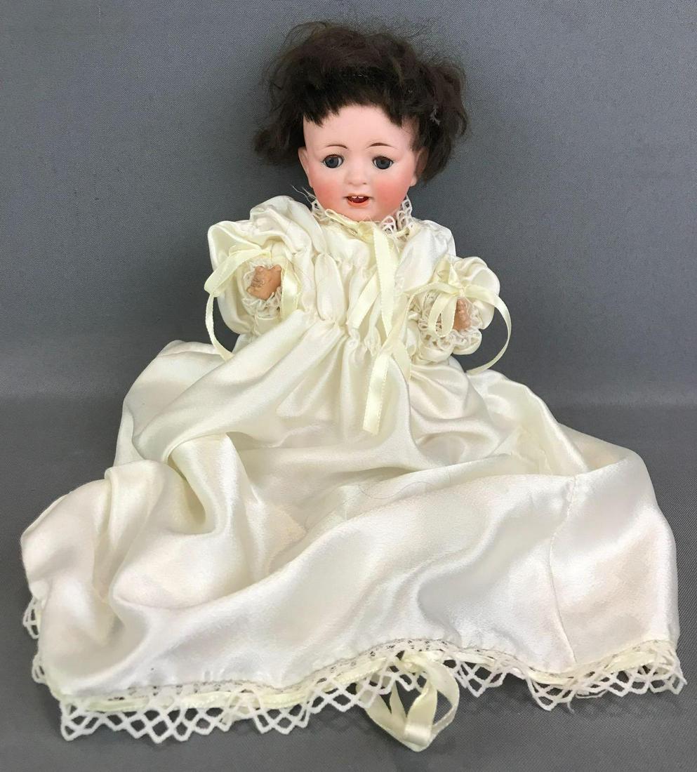 Antique 10 inch German bisque doll Bergmann: CM Bergmann, 2. Socket head, blue sleep eyes with painted and applied lashes, open mouth with 2 upper teeth, composition body. Long gown, diaper. Brown mohair wig. Feet and hands have chips, paint los