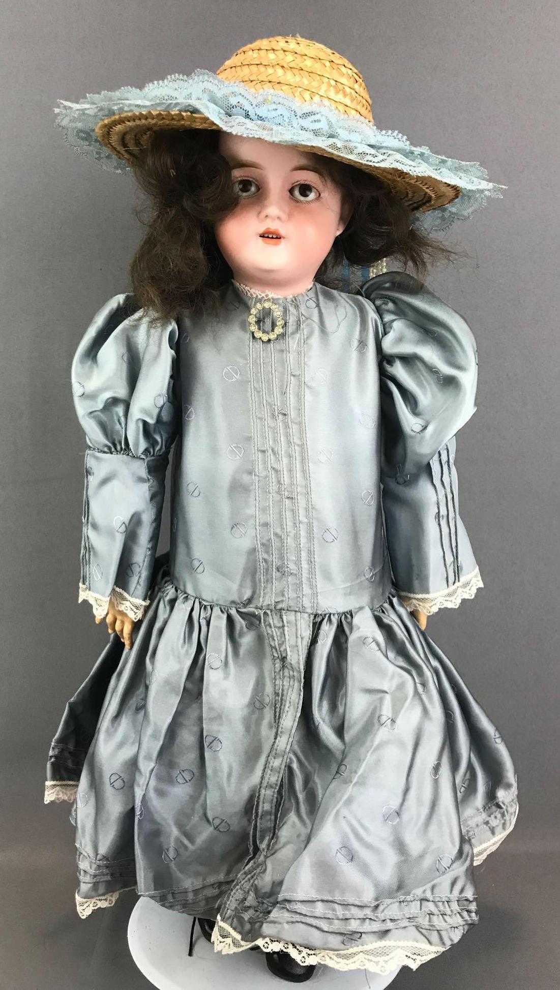 Antique 22 inch German bisque doll Recknagel: 1909, DEP R 7 A. Socket head, brown glass sleep eyes with painted lashes, open mouth with teeth, pierced ears, composition and wood jointed body. Blue dress, under gaments, hat, stockings, shoes. Usua