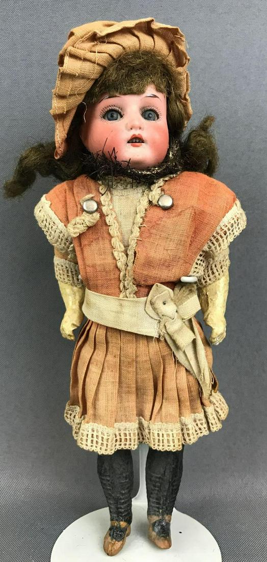 Antique 9 inch German bisque doll Huebach: Heubach Koppelsdorf, 250 15/0. Socket head, blue glass sleep eyes with painted lashes, open mouth with teeth, composition body. Brown mohair wig. Legs are painted with stockings and shoes, clothing ap