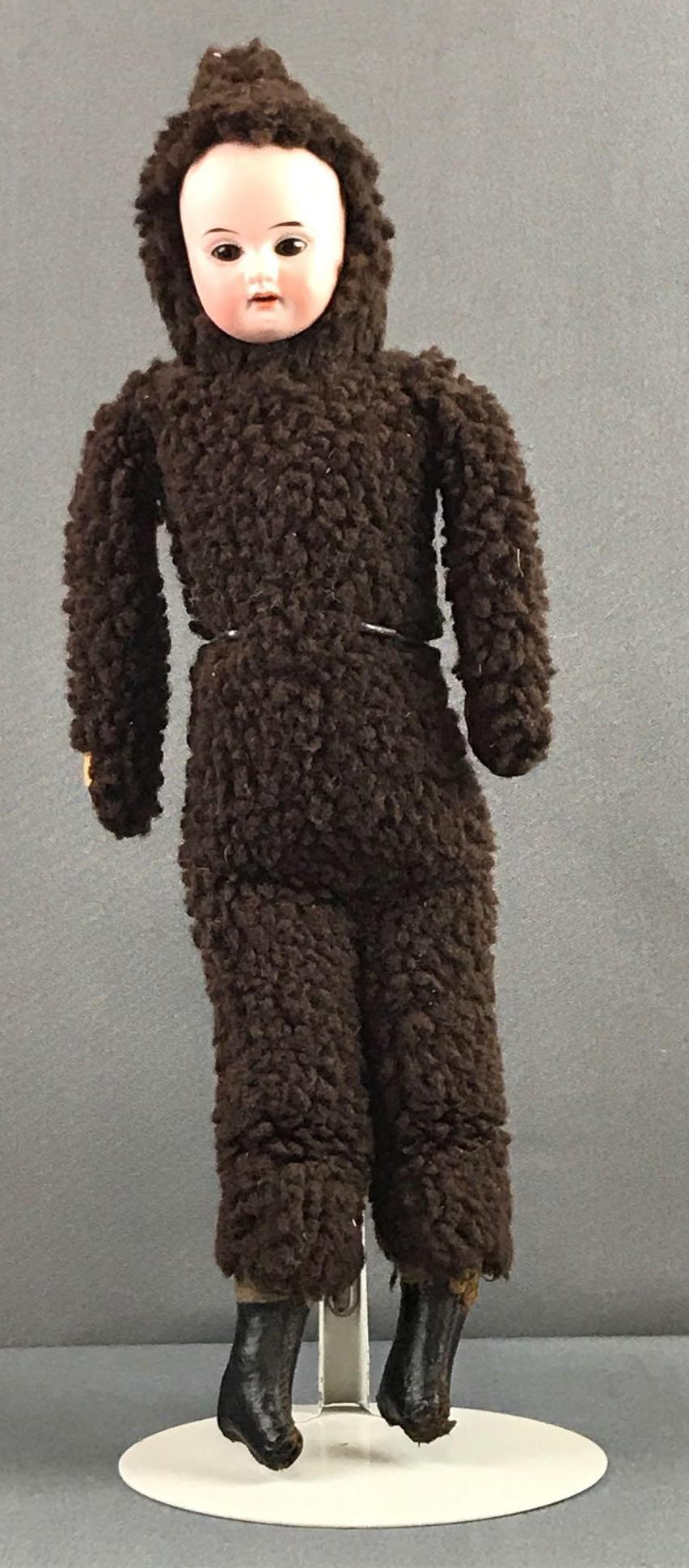 Antique 16 inch German bisque doll with original: Costume is glued to body, Bisque face, not complete head. Brown glass stationary eyes with painted lashes.
