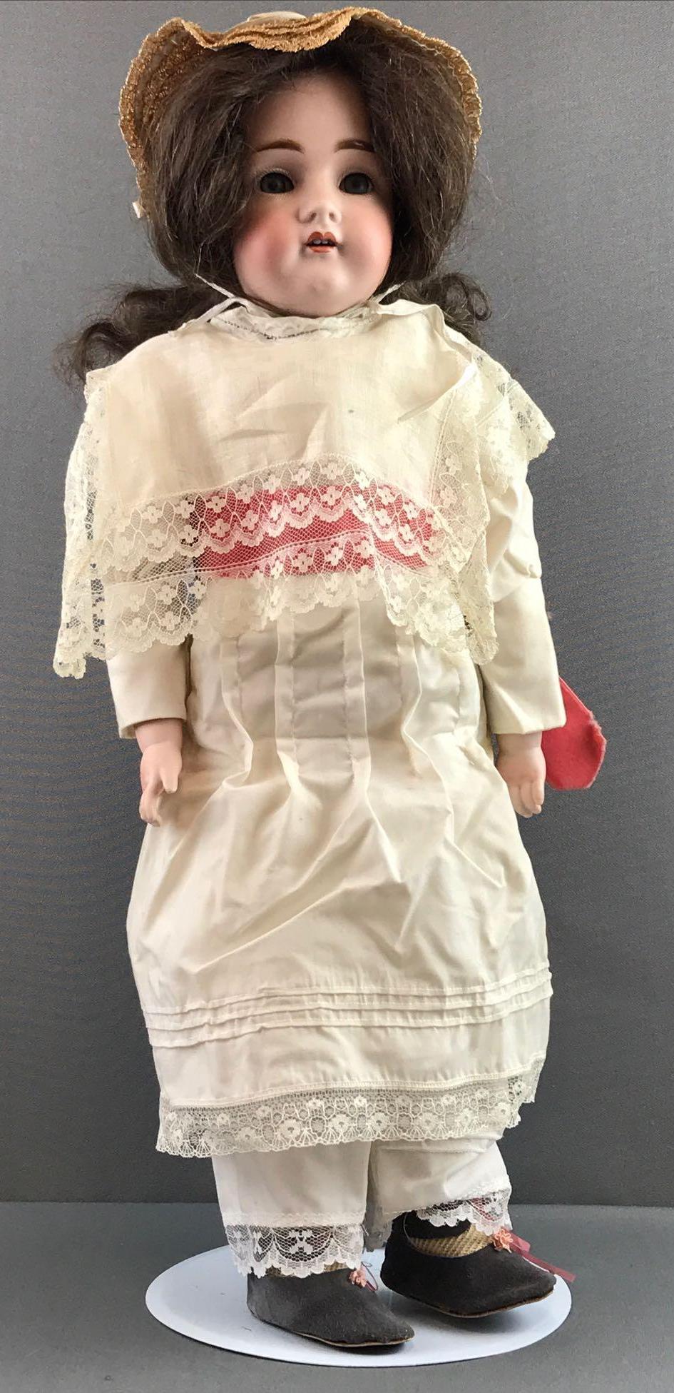 Antique 22 inch German bisque doll Kestner: 11 Dep 154. Shoulder head, blue glass sleep eyes with painted and applied lashes, open mouth with teeth, leather jointed body with bisque hands. Brown wig, attached. Ivory colored dress with lace and 