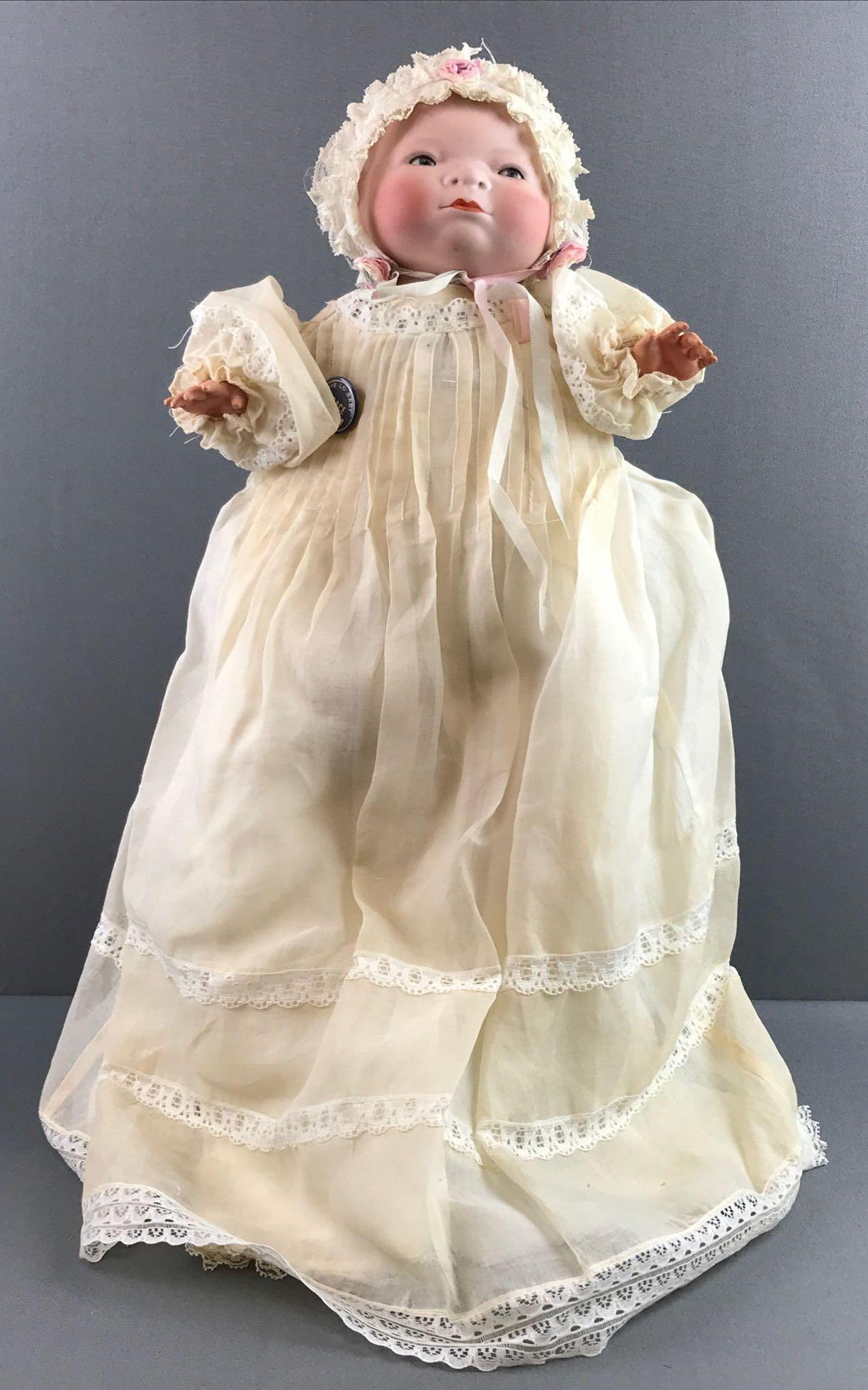 Antique Bye-lo bisque ba Grace Putnam: Celluloid hands, one finger is broken off. Sleep eyes with painted lashes, fabric body. Measures 13 inches. Doll stand not included.