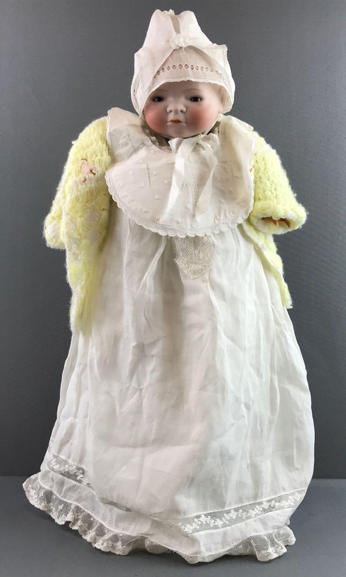 Antique Bye-lo bisque ba Grace Putnam: Crack on head, celluloid hands, one is broken. Fabric body. Measures 17 inches. Doll stand not included.