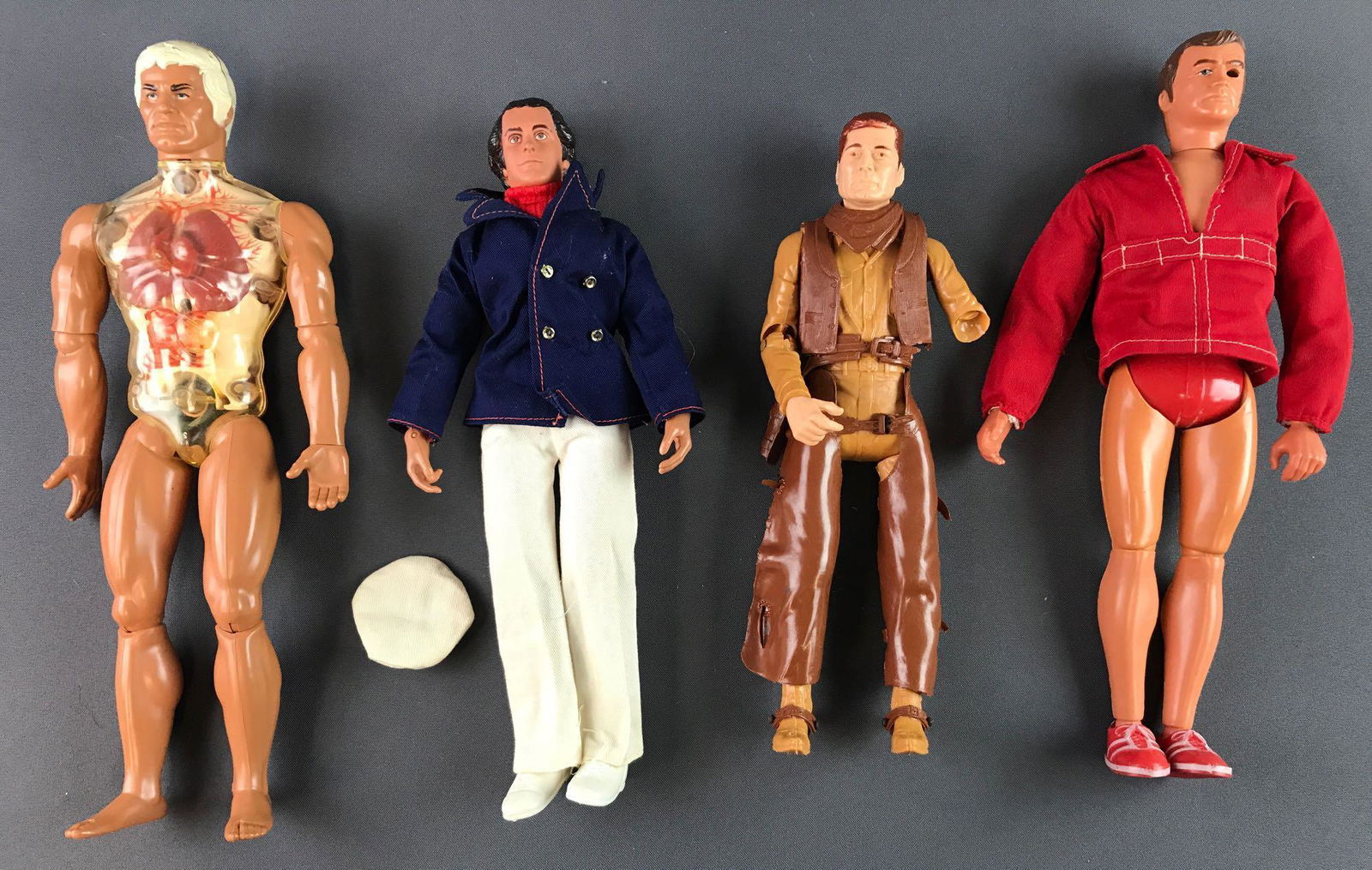 Group of 4 Vintage Male Action Figures: Includes Six Million Dollar Man, Marx Cowboy with missing forearm and hand, Mego Captain David Dragon and Mattel Pulsar. Largest measures 13.5x5.5x2.5 inches. Wear consistent with age and use, in used