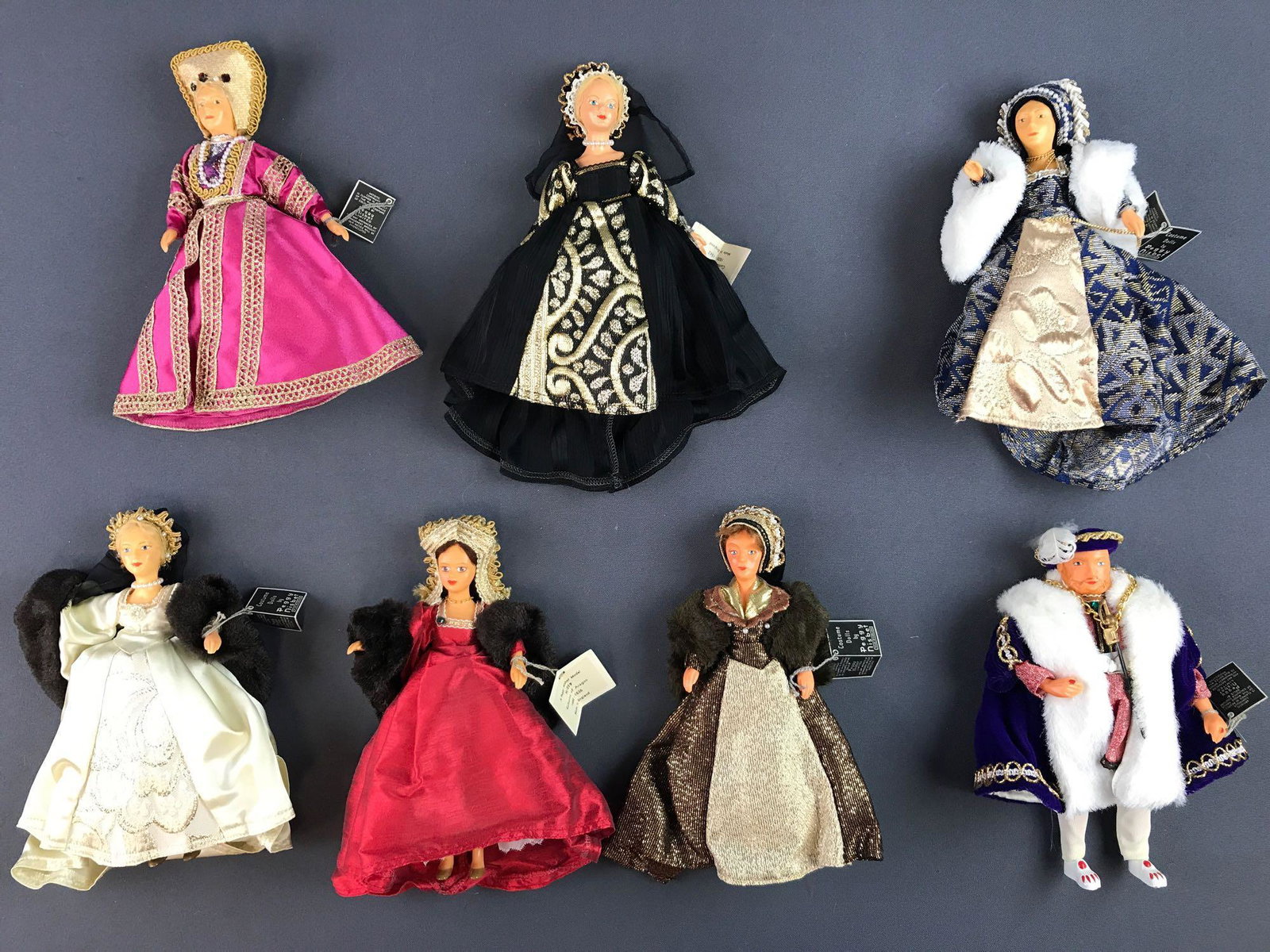 Group of 7 Henry VIII and wives Costume Dolls Peggy: Largest measures 9.5x7.5x1.5 inches. Includes Jane Seymour, Ann Boleyn, Katherine of Aragon and more. Jointed arms, some detached joints.
