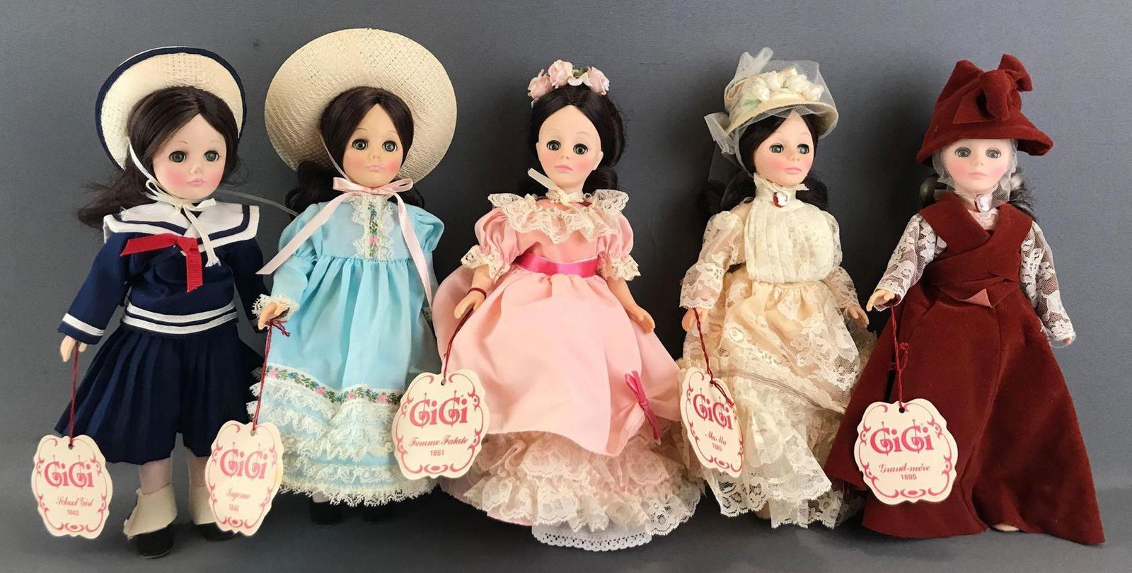 Group of 5 Effanbee GiGi Through the Years dolls: School Girl, Ingenue, Femme Fatale, MaMa, and Grand-mere. Dolls are 12 inches each. Plastic, unknown completion