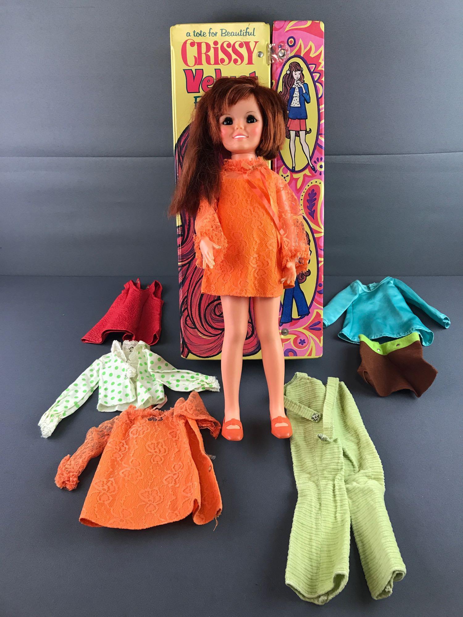 Chrissy Velvet Doll and accessories: By Ideal and includes case measuring 19x8.5x3 inches, dresses and jumper and doll with sleepy eyes in working condition. In used condition, snap missing from case.