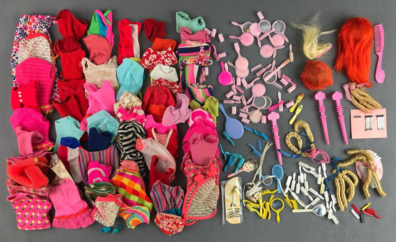 Group of 100+ Mattel Barbie fashion clothing, beauty: Includes swimsuits, tops, brushes, mirrors, wigs and more. Includes duplicates, in used condition.