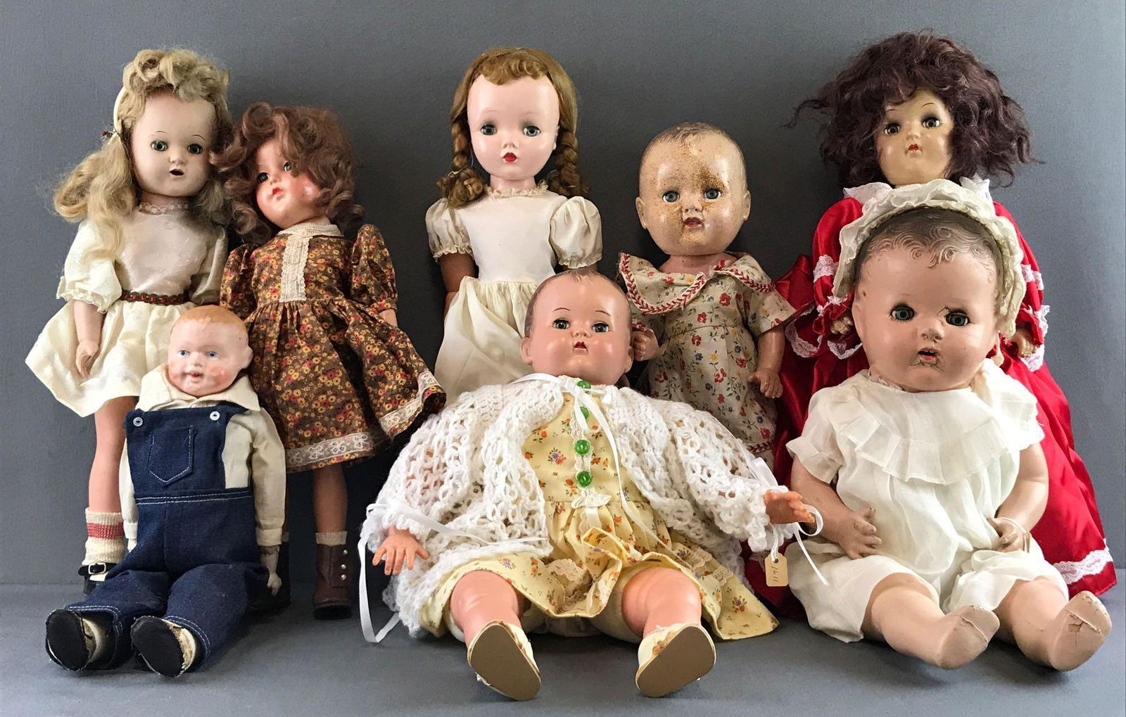 Group of 8 assorted vintage dolls: Includes composite head, soft body, leather body, bisque, sleepy eyes and more. Includes dolls by Ideal Doll, Effanbee, and more. Largest measures 17.5 inches. Some paint chipping and crackling, in us
