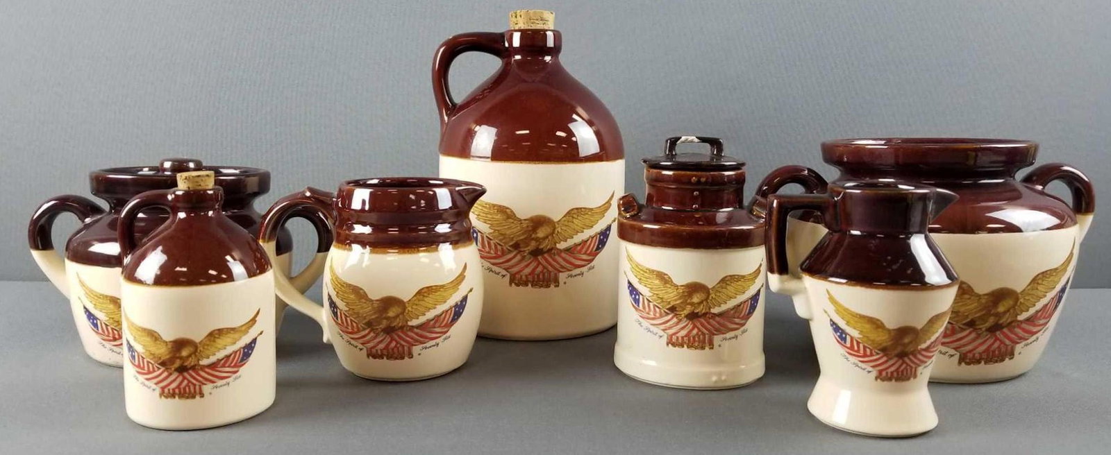 Group of 7 vintage McCoy patriotic stoneware jugs and: Includes pitchers, jugs, covered crocks. A couple of chips. Largest is 10.5 inches tall