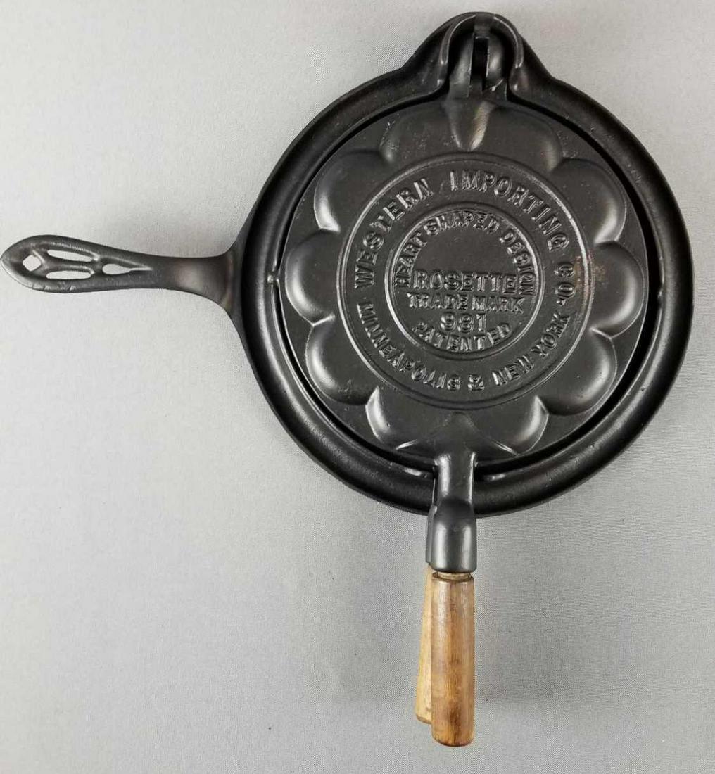 Heart shaped cast iron rosette/waffle iron: Western Importing co. #981 pattern, base #8/975. Wooden handle is loose. Base measures 14.5 x 11 inches