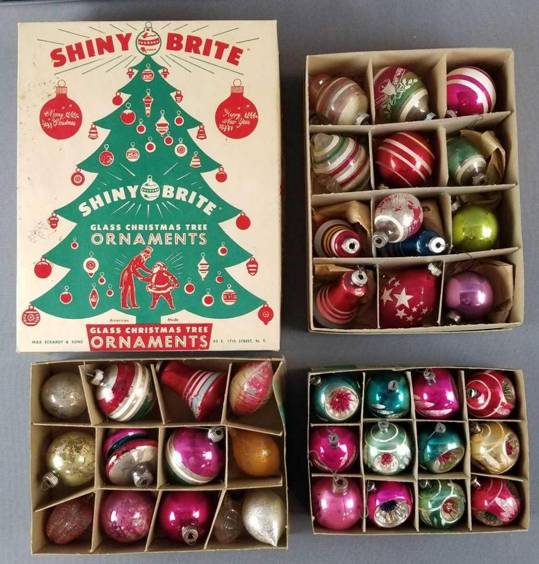 Group of vintage Shiny Brite Christmas tree ornaments: 3 Shiny Brite boxes filled with various glass ornaments. Additional unmarked box. Condition consistent with age and use. Circa 1940s-1950s.