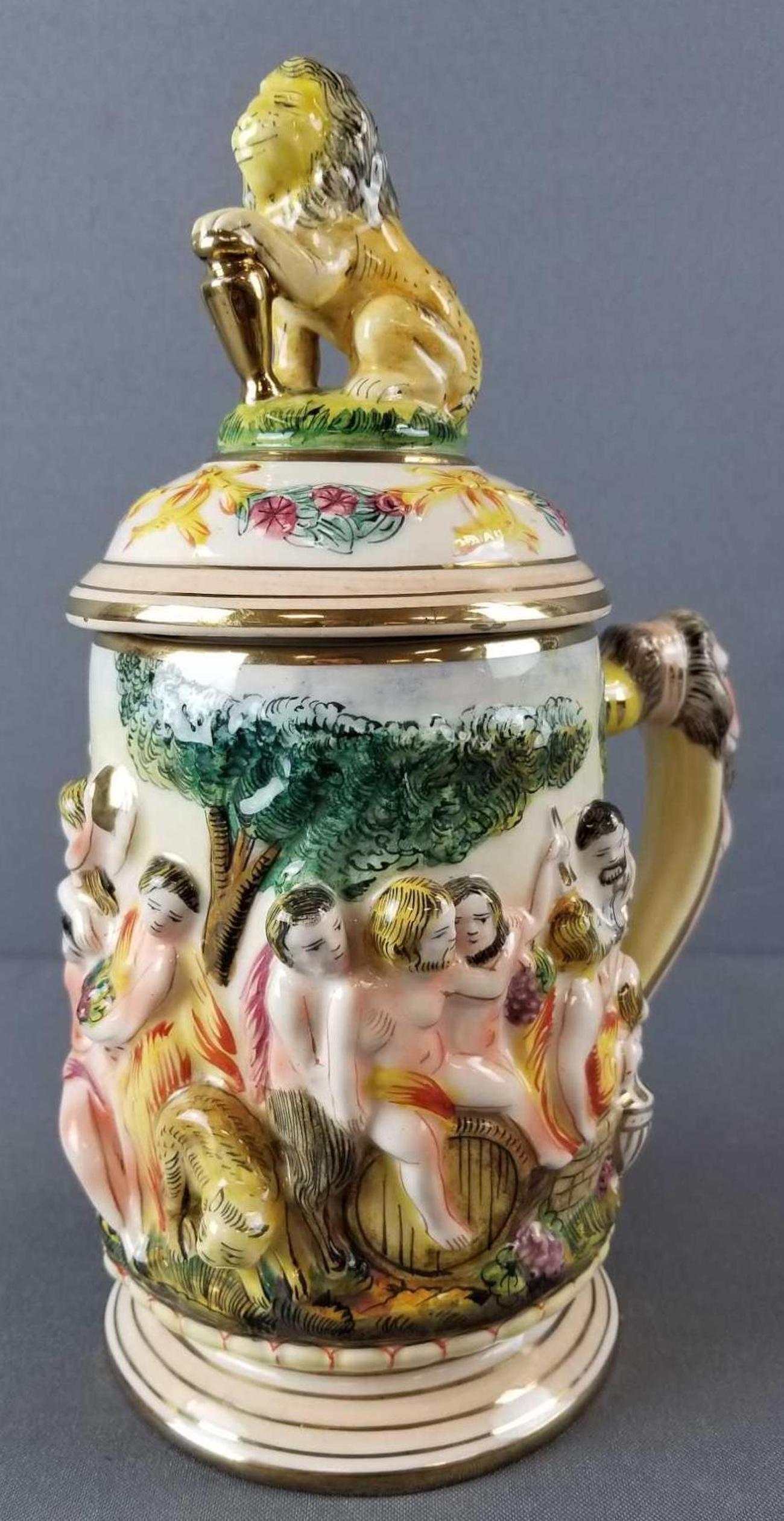 Capodimonte high relief lidded stein: Features lion finial on lid, bacchanal theme. Some minor wear. Stands 10.5 inches tall. Bottom reads 2067 Italy Capodimonte