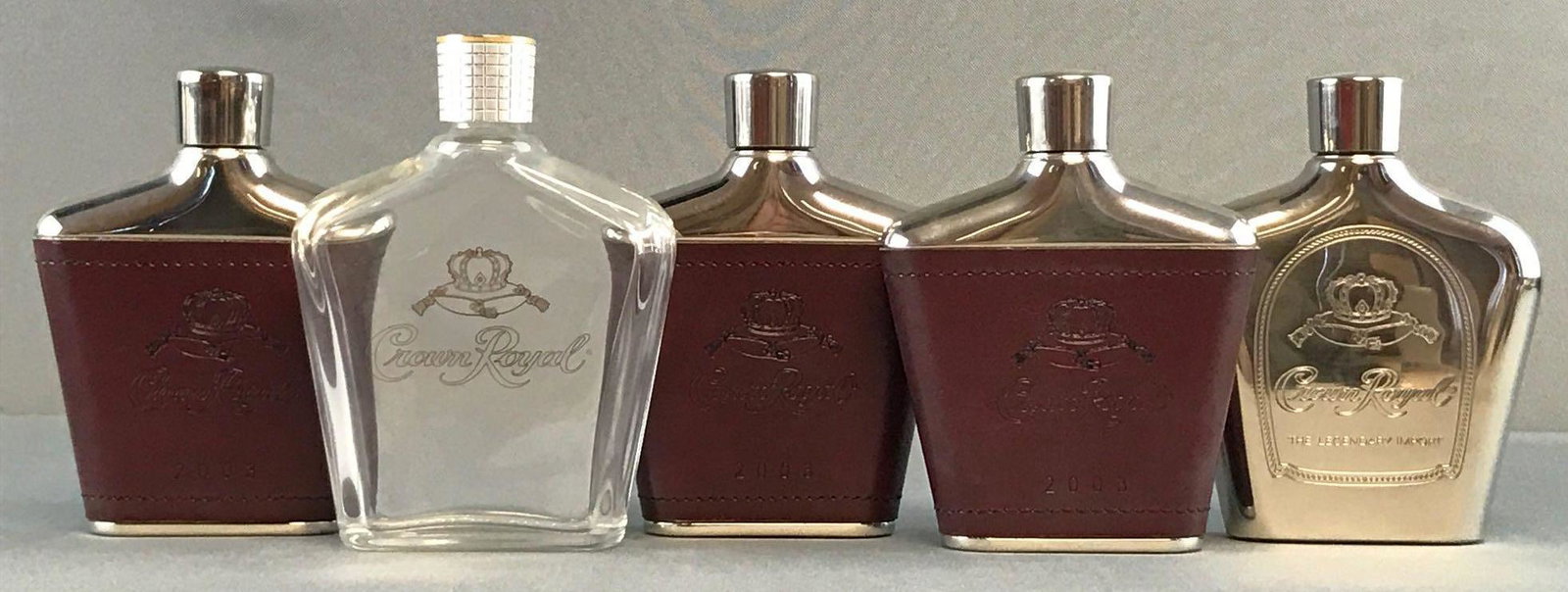 Group of 5 Crown Royal advertising flasks: Includes stainless steel 6oz and glass flask made in Italy measuring. 5x3x1.5 inches.