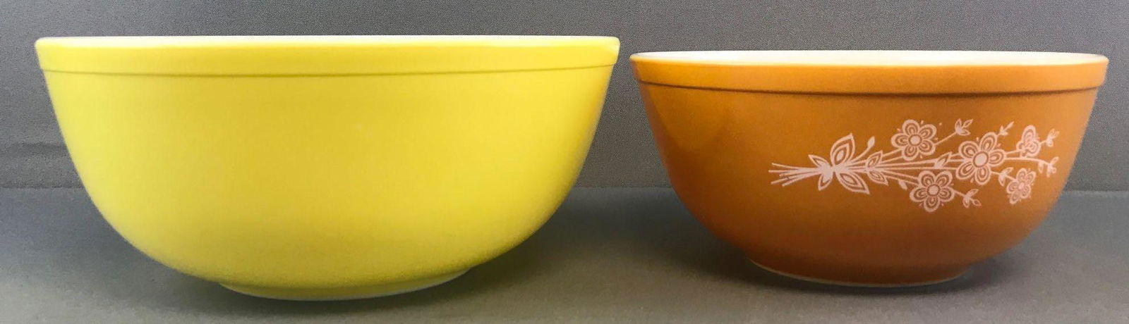 Pair of vintage Pyrex mixing bowls: Yellow-10.5x4.5 inches and Butterfly-8.75x4 inches. Wear consistent with age and use