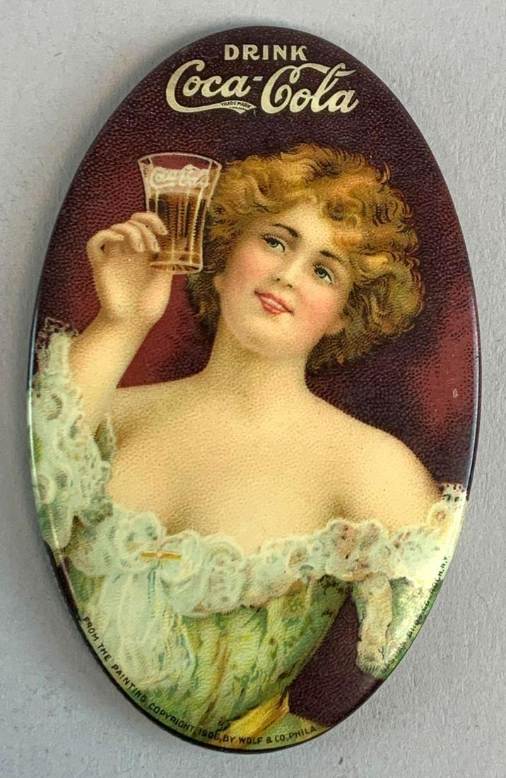 1907 Coca-Cola Pocket Mirror: A nice looking mirror with a wonderfully smooth surface and only light to very moderate surface wear. Condition: 8.9 - 9.2, Near Mint. Dimensions: 3" x 1 - 3/4".