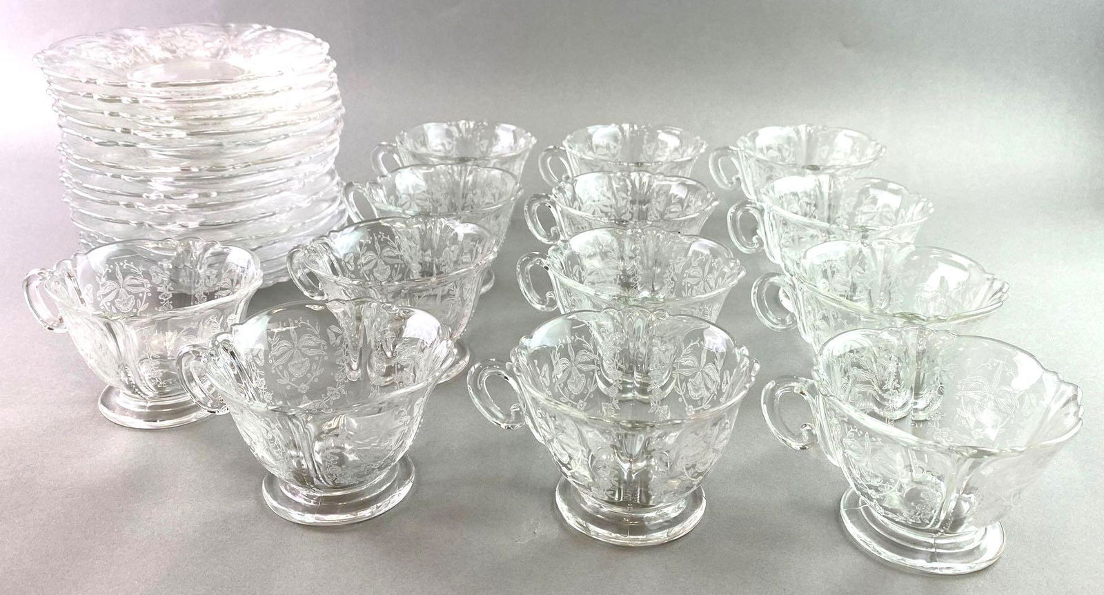 Group of 28 Heisey Orchid Pattern Tea Cups and Saucers: Includes 15 saucers and 13 cups. Saucers measure approximately approximately 6 1/2 inches in diameter. The tea cups measure approximately 2 5/8 inches tall by 3 7/8 inches wide. These are in excellent