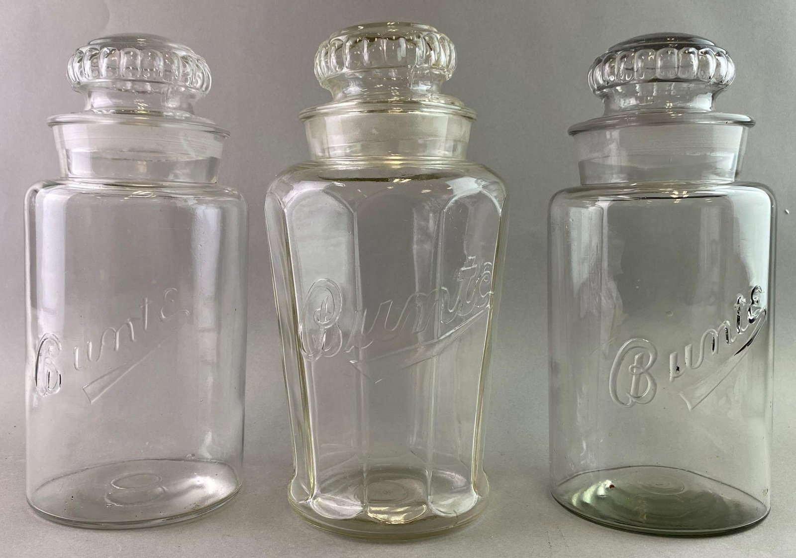 Group of 3 Bunte Candy Jars Chicago: All 3 jars measure approximately 12 inches tall. They have small flea bites and little chips. Bunte candy was founded in Chicago in 1876.
