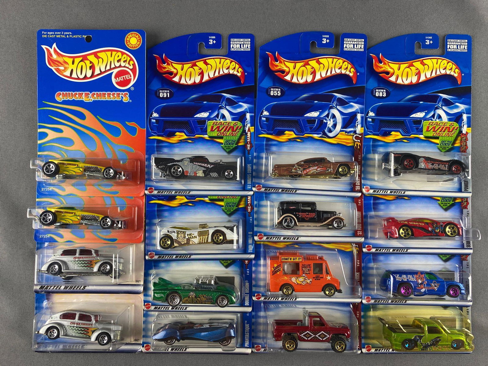 Group of 16 assorted Hot Wheels die-cast vehicles: Includes He-Man 41 Willys Coupe, Yu-Gi-Oh Super Tuned, Wild Frontier Ice Cream Truck, and more. New in original packaging. Mattel, Inc.