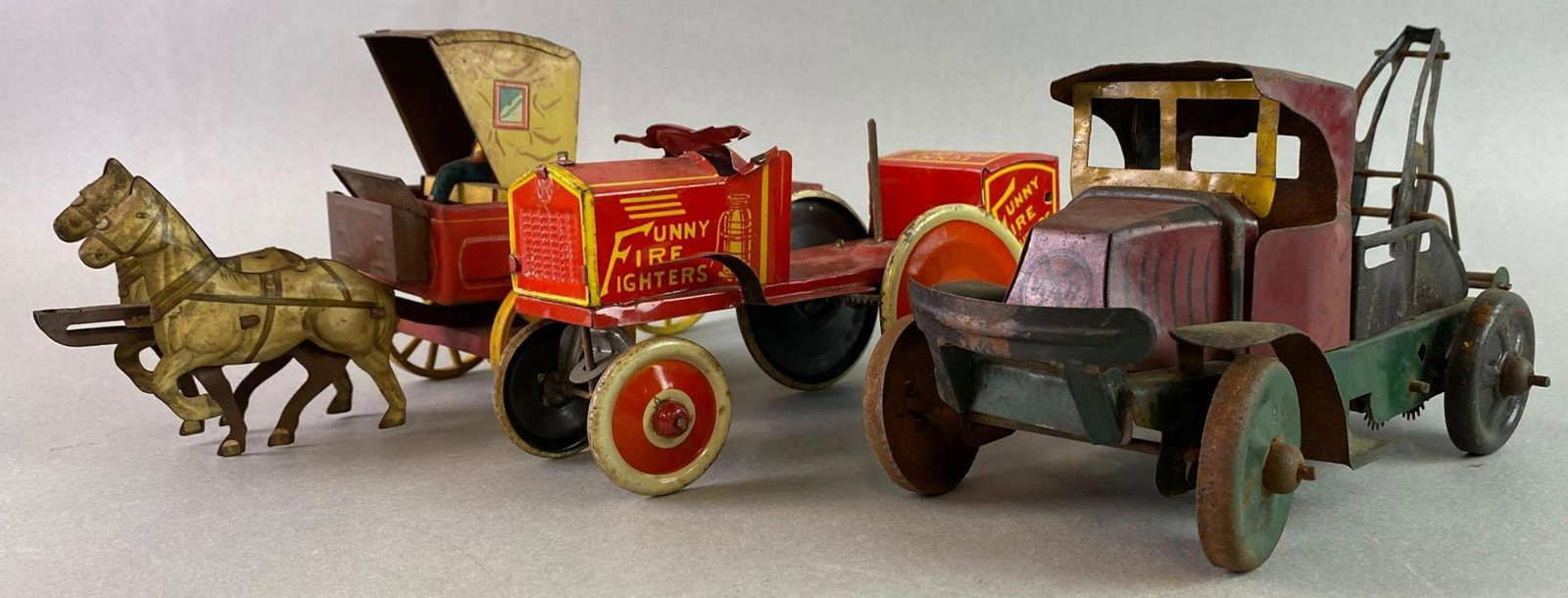 Group of 3 Tin Litho: Includes Truck, Fire Truck, Wagon. Fire Engine works. Tow truck measures approximately 10 x 5 inches.