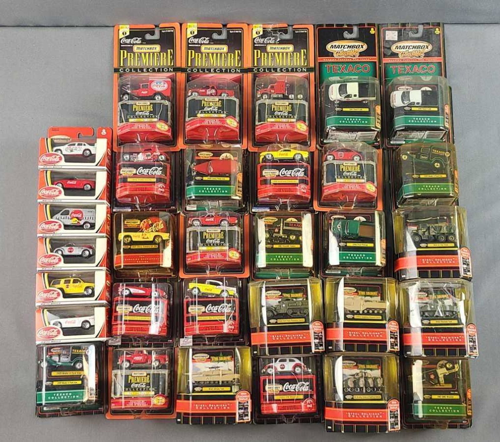Group of 32 Matchbox collectibles die cast vehicles: Coca-Cola, Texaco, Steel soldiers. In original packaging
