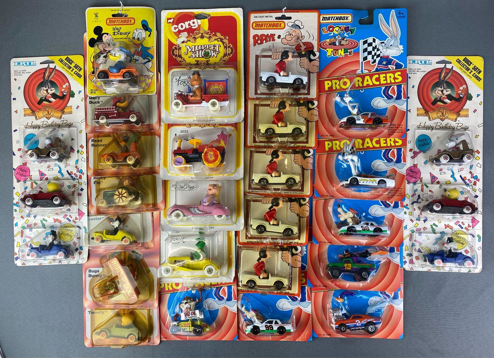 Group of Licensed Die Cast Vehicles: Includes matchbox, Ertl, and Corgi. Includes The Muppets, Warner Brothers, Popeye and more