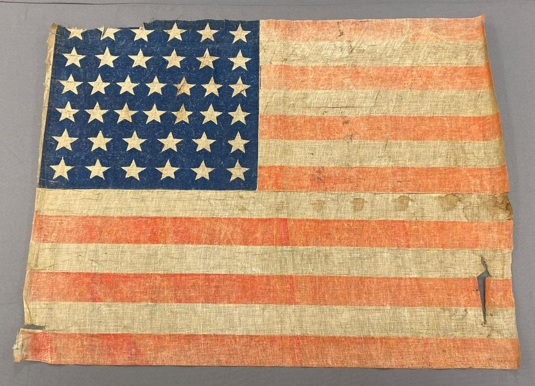 American Flag with 38 Stars: Measures 28.5x35.5 inches. Fraying on all edges, several tears and stains.