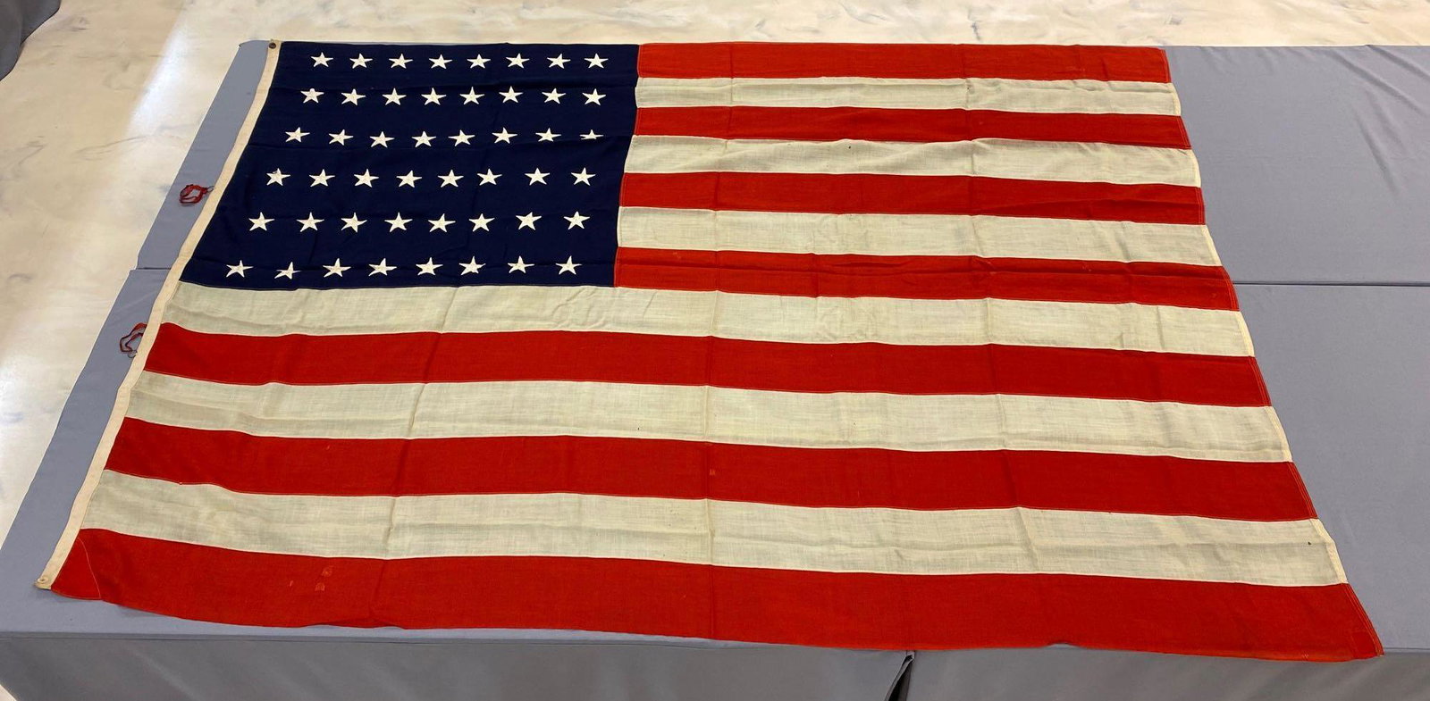 48-Star Flag: 103x72 inches, machine sewn cotton, individual stripes, embroidered stars, repairs, small holes,