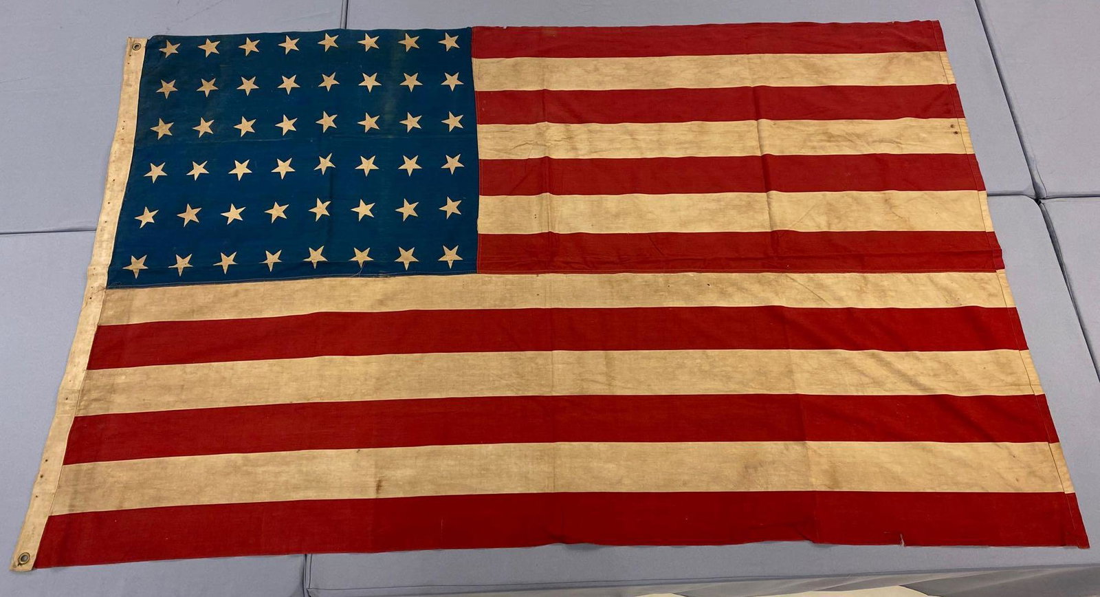 48-Star US Flag: 91.5x56.5 inches, machine sewn cotton, printed stars and stripes, some holes, discoloration, repairs