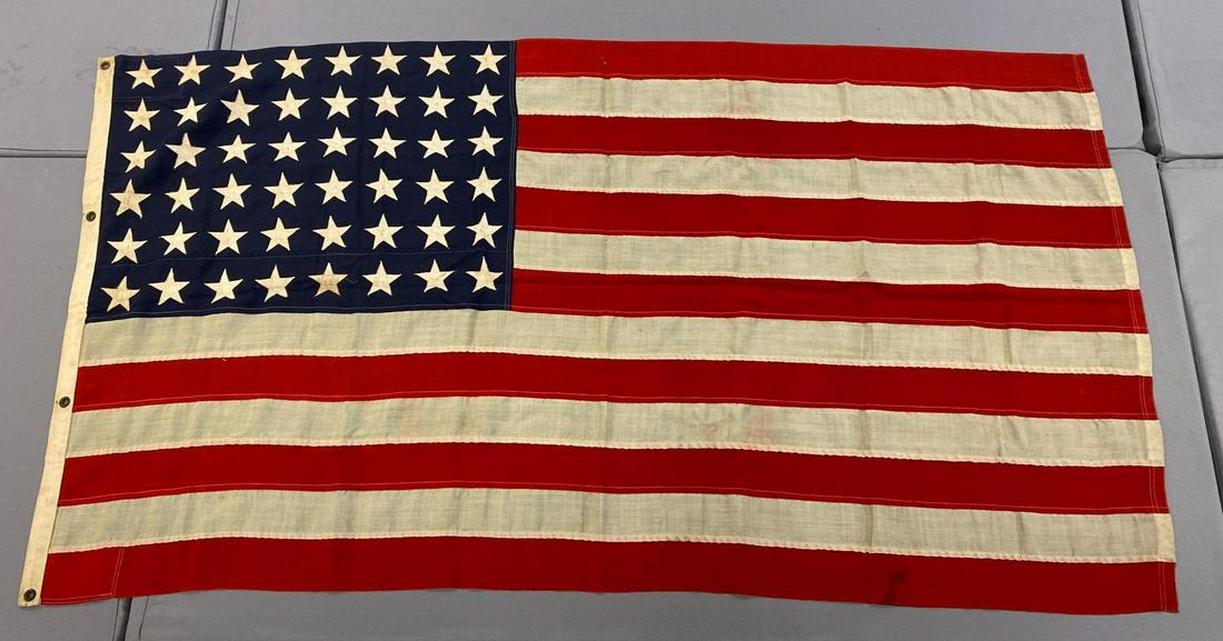 48-Star US Flag: 76x42 inches, machine sewn cotton, individual stripes, applique stars, some small holes, stains