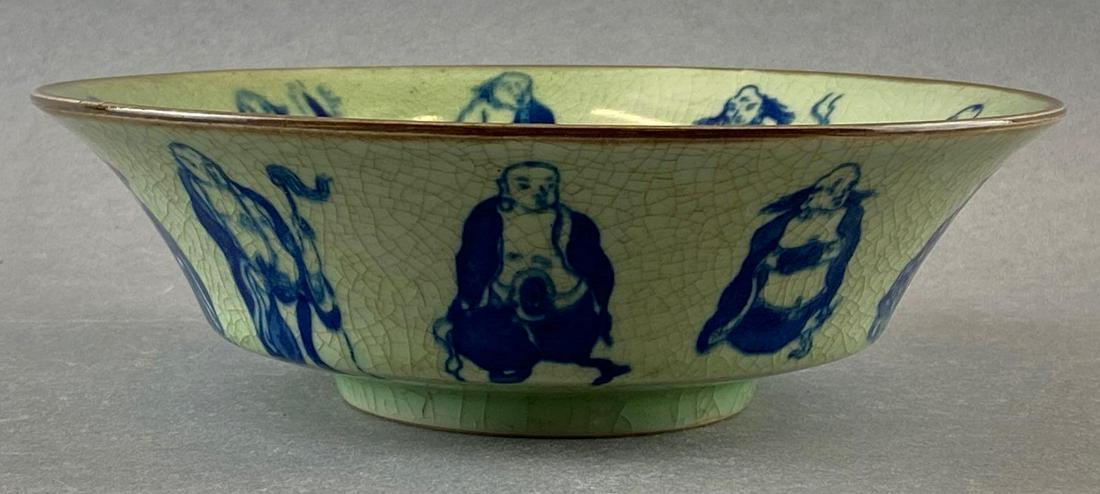 Chinese Bowl with the 18 Buddhist Arhats: Blue figures around bowl rim with dragon image in center. Crazing throughout. Measures 9in in diameter.