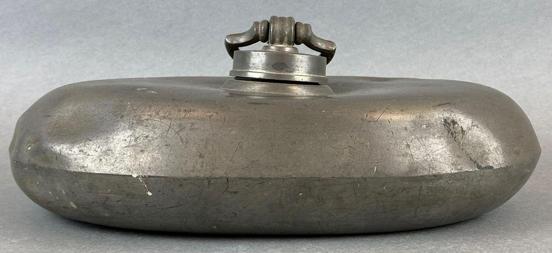 19th Century Foot/Bed Warmer: Top loading water container. Handle engraved with name Nussmann and insignia. Some dents and markings. Measures 12.5in across.