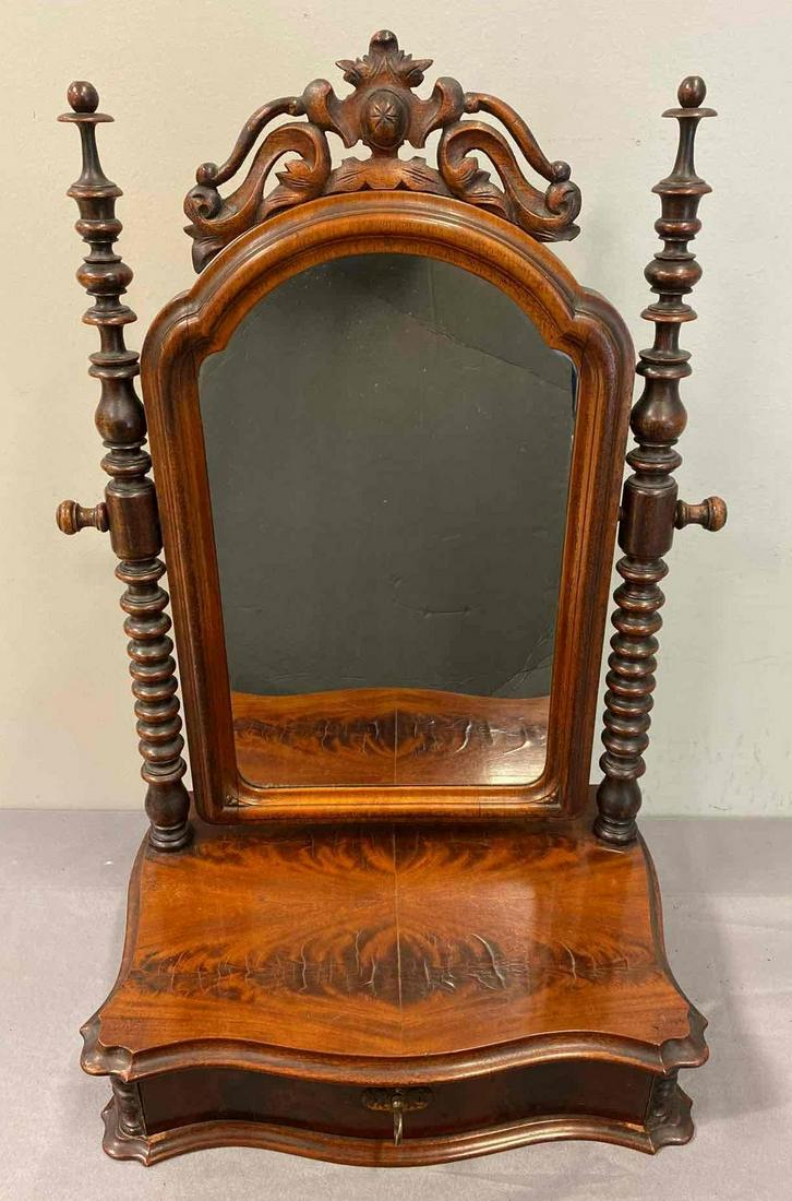 19th Century Dresser/Sahving Mirror: Ornate hand carved spindle rails, arched mirror, flame mahogany base with locking drawer. An exceptional example. Measures 27.5 x 17 inches. Includes key