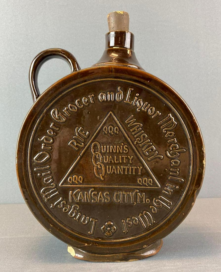 Quinnðs Quality Quantity Advertising Flask Bottle: Circa 1900, a canteen style jug in brown glaze with an applied handle, embossed 'Quinn's Quality Quantity Rye Whiskey, Kansas City, Mo.' and 'Largest Mail Order Grocer and Liquor Merchant in the West.
