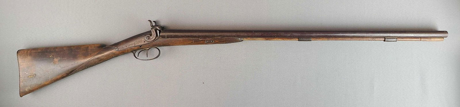 Antique Double Barrel Black Powder 12 GA Shotgun: Muzzle Load, Serial Number NA, 33 inch Barrel, Side by Side, 49 inch Total Length, Includes Push Rod, Marked "Real Twist" on Barrel. Crack in stock, Chips in Forend, Missing Screw.