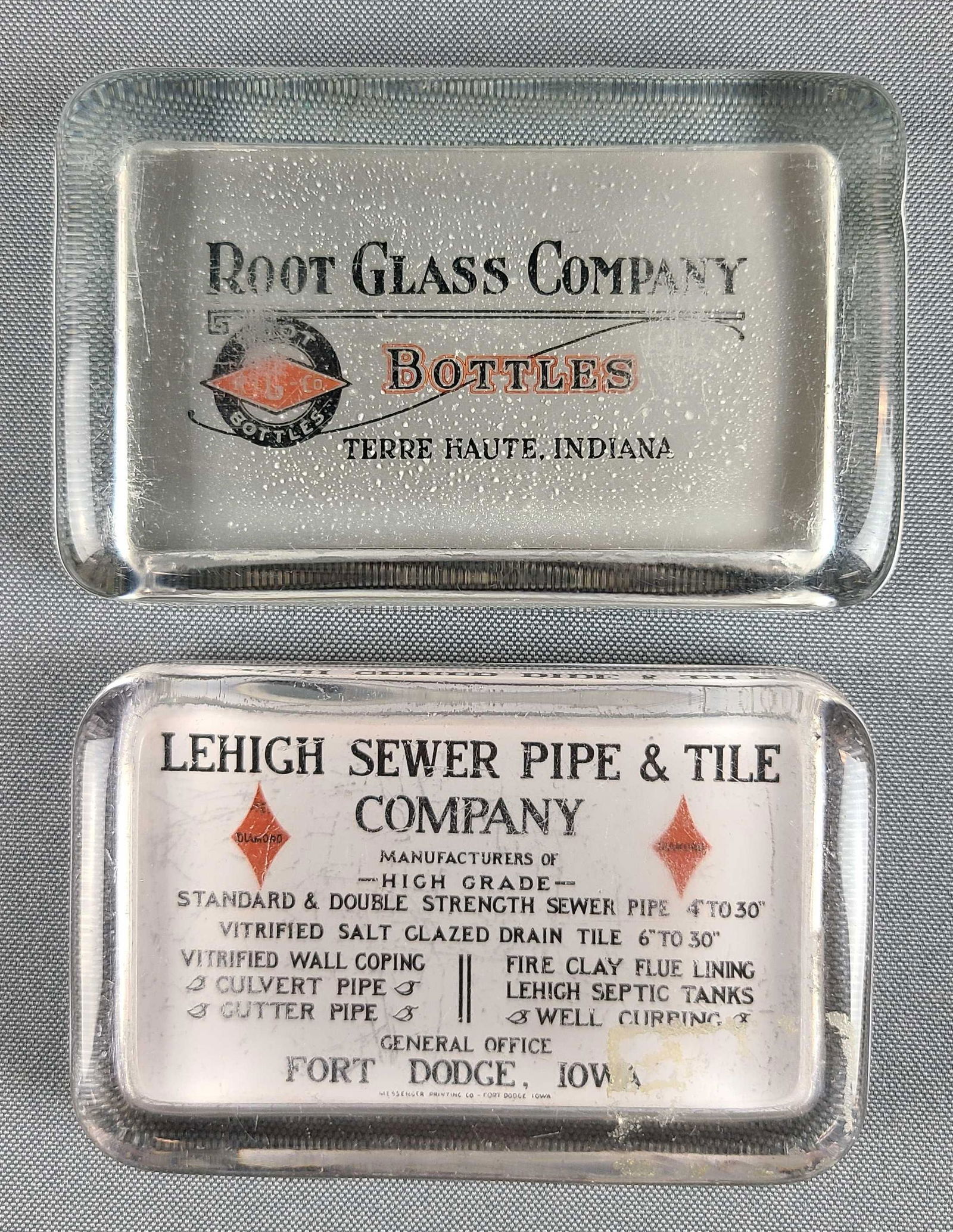 2 glass advertising paperweights: Root glass company, Lehigh sewer pipe and tile company. One has mirror on back. 2 3/4 x 4 1/4 inches.