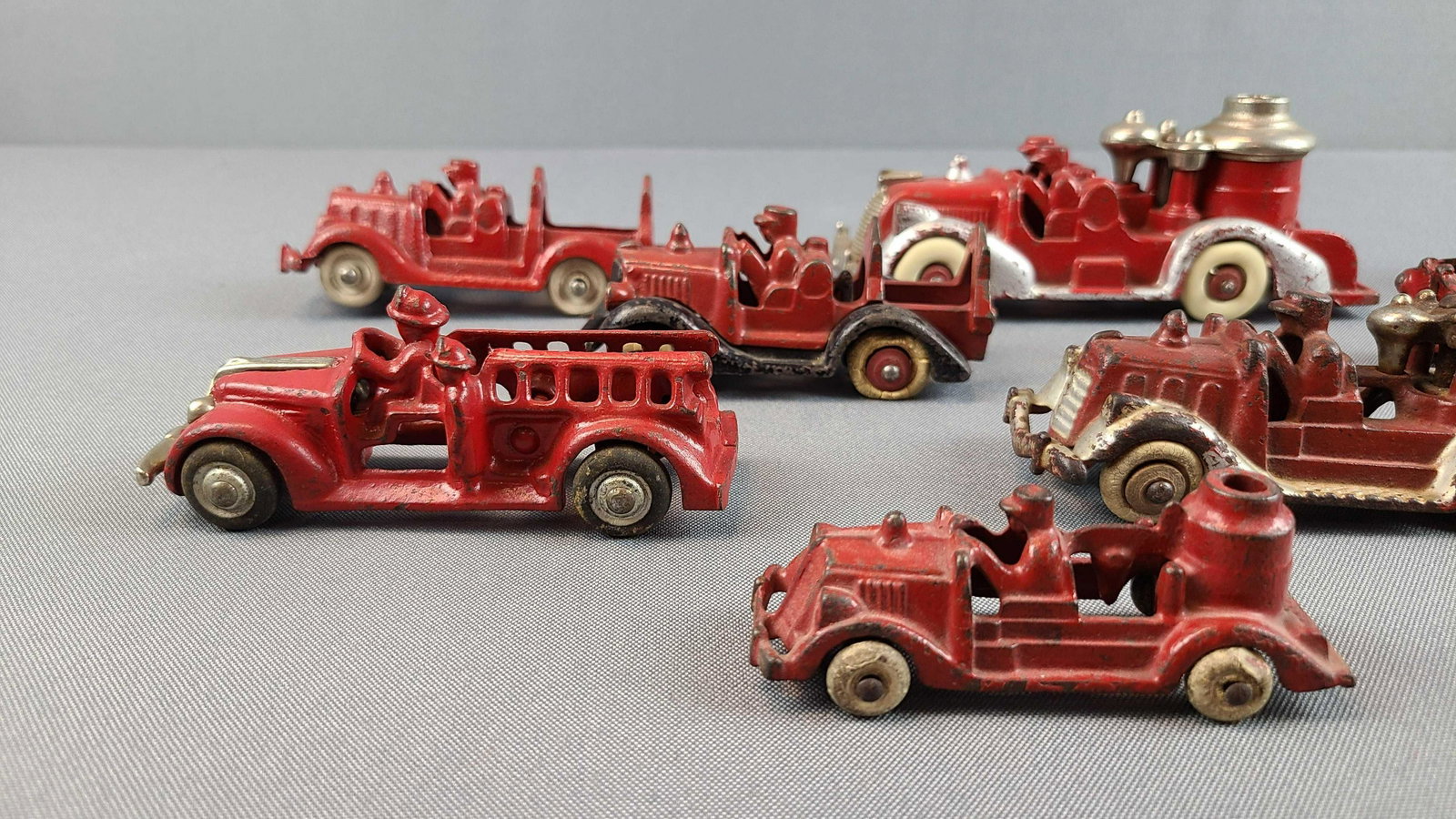 Group of 10 Cast Iron Fire Trucks: Largest is 6 1/2 inches long. Some paint loss, missing tires. Hubley, unmarked. One is cracked.