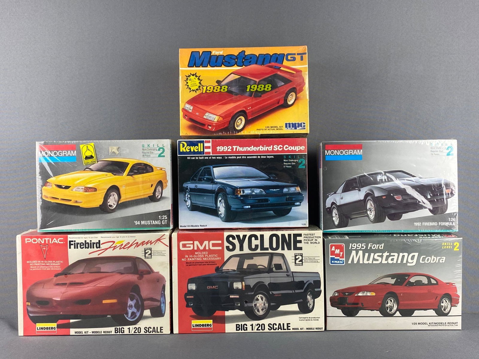 Group of 7 Assorted Vehicle Model Kits: All sealed. Includes Lindberg GMC Syclone, ERTL 1995 Ford Mustang Cobra, Monogram 1992 Firebird Formula, and more.