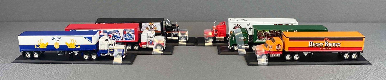 Group of 6 Matchbox Semis: Includes Honey Brown Mack Beer Semi, Moosehead Beer Kenworth Cab Over Semi, Red Dog Beer Ford Aeromax Semi, and more. Original shipping box with COA.