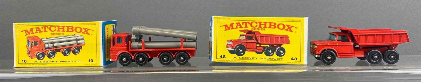 Group of 2 Matchbox No. 10 and 48: Red. Includes Pipe Truck and Dodge Dumper Truck. A Lesney Product. Black plastic wheels. Original box. Made in England. Die-cast.