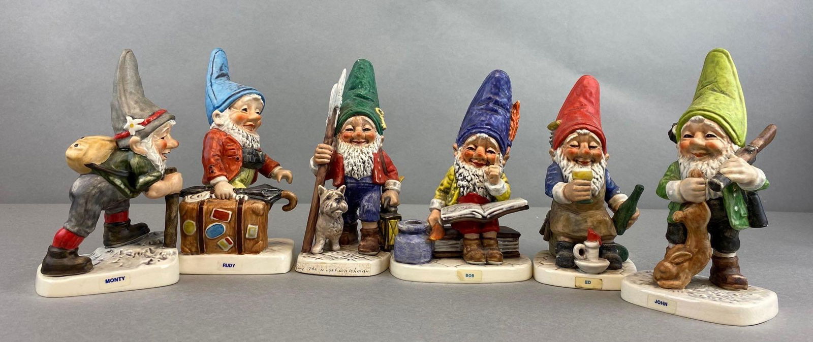 Group of 6 Assorted Goebel Gnome Porcelain Figurines: Includes Bob, Ed, John, and more. Largest measures 8 1/2 x 4 x 3 inches.