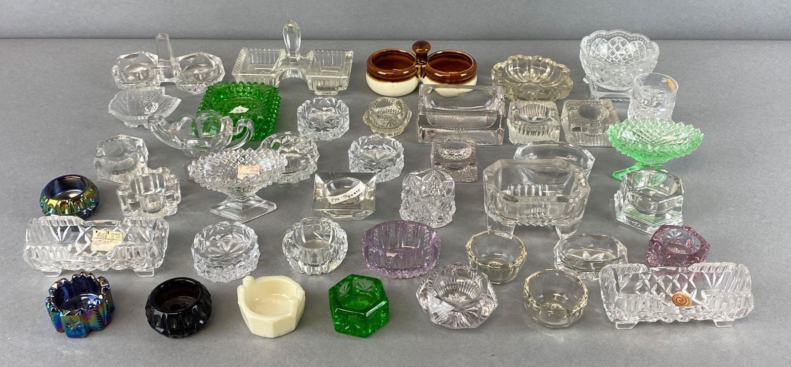 Group of 40+ Assorted Glass Salt Cellars and More: Includes cut glass, uranium glass, iridescent, amethyst, and more, largest measures 3 x 4 3:4 x 2 1/2in.