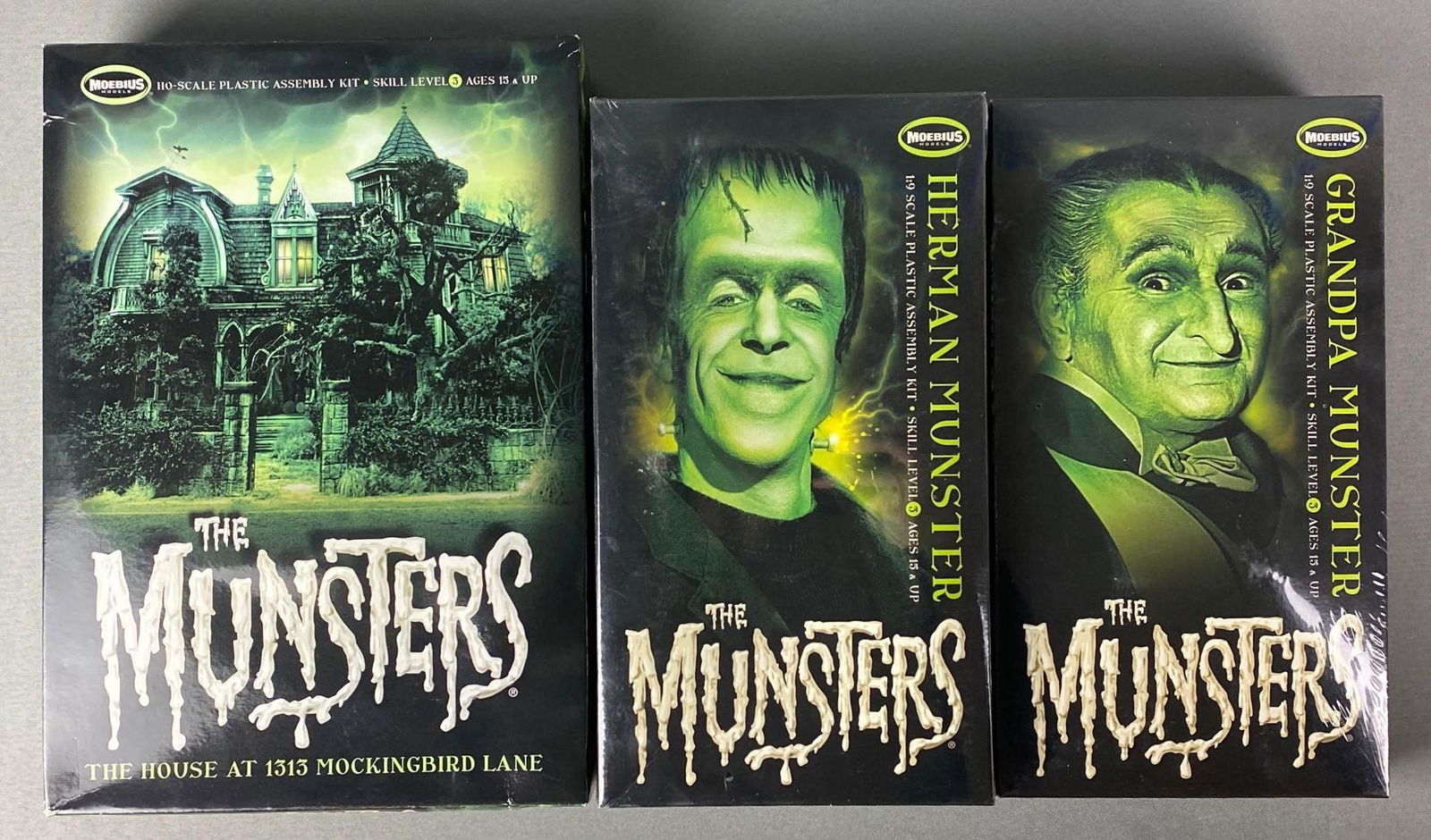 Group of 3 The Munsters Assembly Kits: Includes Grandpa Munster and Herman Munster (1:9 scale) and The House at 1313 Mockingbird Lane (HO) scale. All are sealed, one box is opened but contents are sealed.