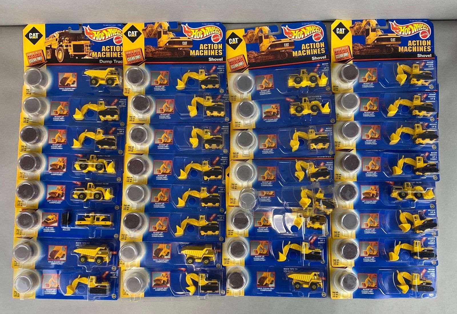 Group of 50+ Hot Wheels CAT Action Machine Sets: Mattel. 1997. Includes No. 17990 Dump Truck, No. 17989 Shovel, No. 17993 Wheel Loader, and more. Most not attached to backing. In original packaging. Packaging measures 6 1/2 x 9 1/4 x 1 1/2in.