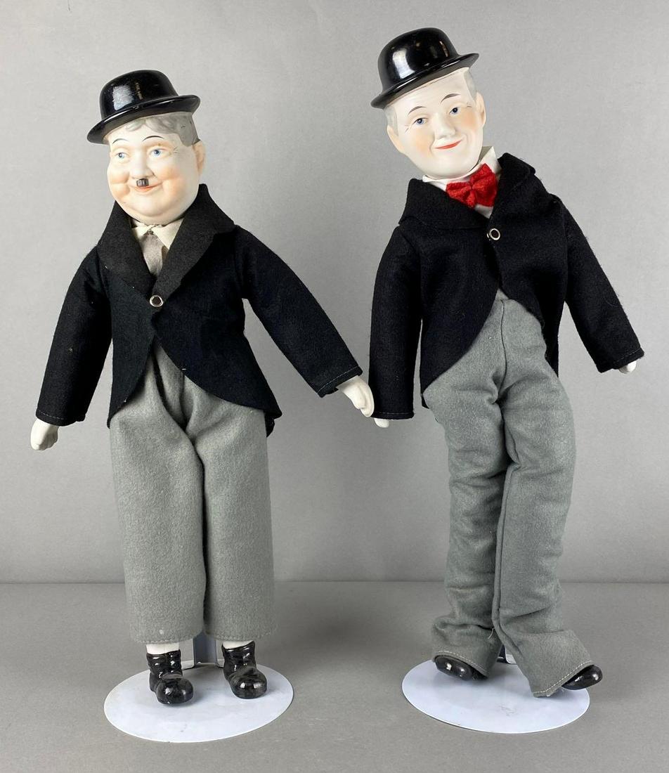 Group of 2 Laurel and Hardy Porcelain Dolls: Porcelain heads, hands, and feet, with cloth bodies, unmarked, With doll stands, Some chips and cracks, Tallest measures 20 1/2 x 8 1/2 x 6in.